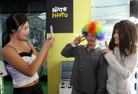 Jae Hee Lee (on left), president of Incheon International Airport Corporation, Sang Su Ahn (center), governor of Incheon City, and Shin Bae Kim (on right), president of SK Telecom, are shown testing the satellite DMB services at the opening ceremony of the ubiquitous service center called `U-Zone` which is located on the 3rd floor of the Incheon International Airport.